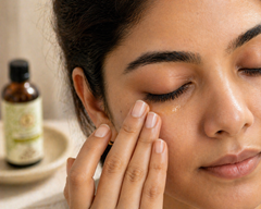  Indian woman applying cold pressed almond oil to under-eye area for dark circle reduction — pure badam tel for bright eyes