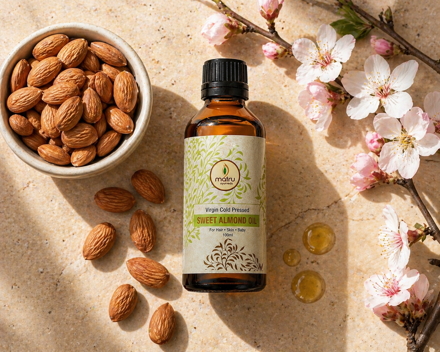 Whole raw almonds in a ceramic bowl beside Matru Ayurveda cold pressed sweet almond oil bottle — pure natural badam tel source ingredient