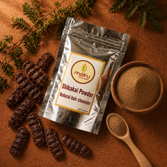 Dried Shikakai Acacia concinna pods and brown powder in a wooden bowl beside Matru Ayurveda pouch — pure natural hair cleanser source ingredient